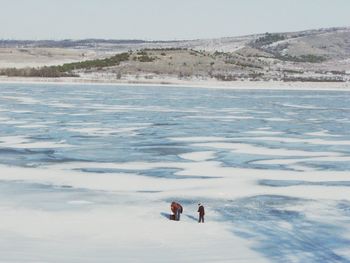 People on beach against sky during winter