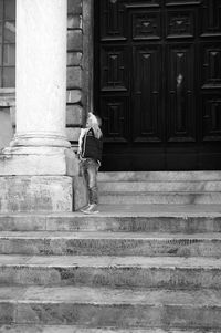 Rear view of woman walking on staircase of building