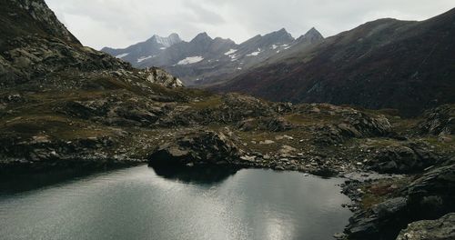 Scenic view of river and mountains against sky