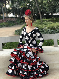 Young woman looking away while sitting outdoors