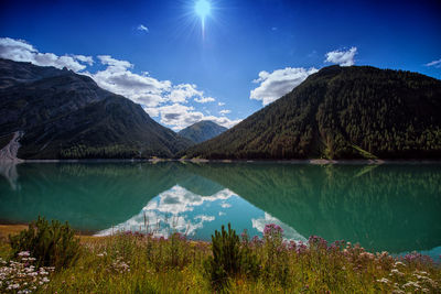 Scenic view of lake and mountains against blue sky