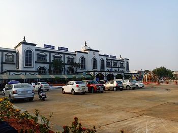 Cars on road by building against sky