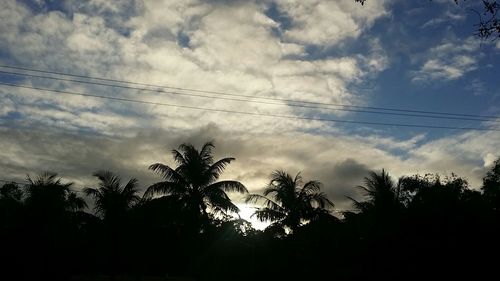 Low angle view of power lines against cloudy sky