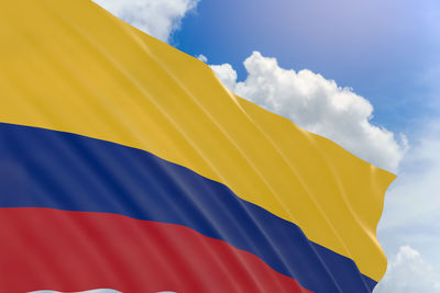Close-up of yellow flag against blue sky