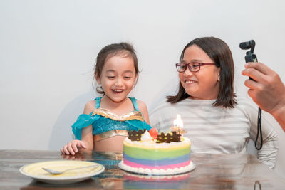 Portrait of a smiling siblings looking at cake