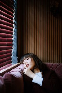 Woman lying on bed at home