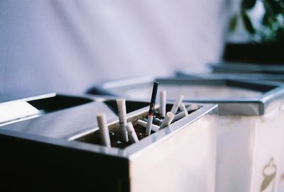 Close-up of cigarette butts in container