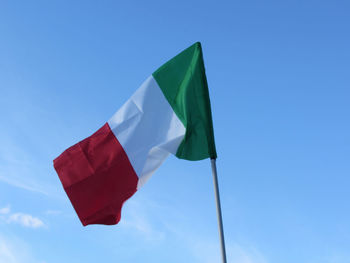 Low angle view of flag against blue sky