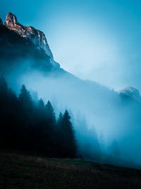 Trees on mountain against sky during winter