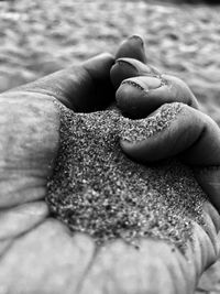 Close-up of person hand holding sand