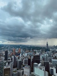 Aerial view of buildings in city against storm clouds