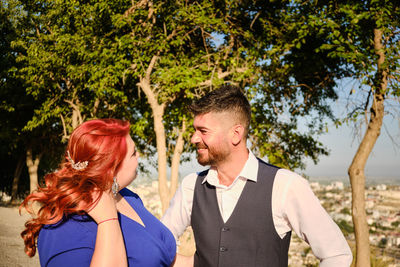 Portrait of couple kissing against trees