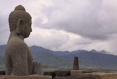 Statue of buddha against cloudy sky