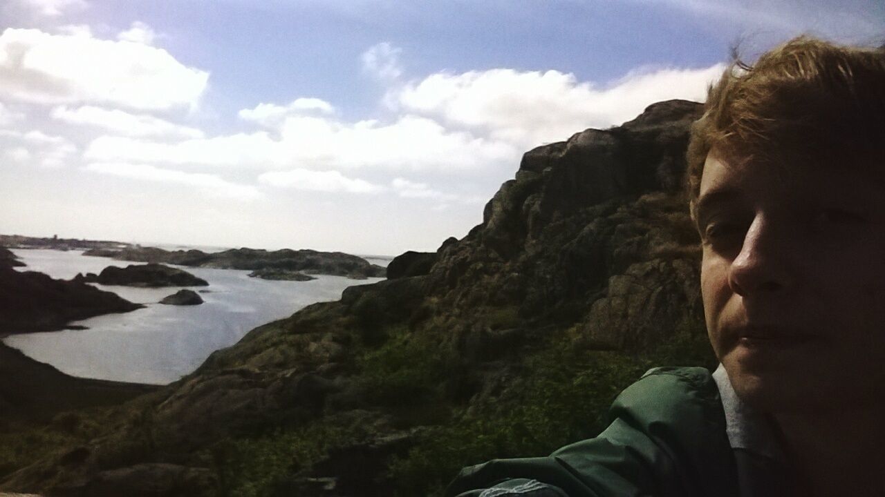 lifestyles, leisure activity, sky, water, headshot, sea, cloud - sky, nature, rock - object, scenics, tranquility, beauty in nature, mountain, young adult, tranquil scene, cloud, day, looking at view