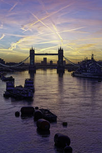 Bridge over river against sky during sunset