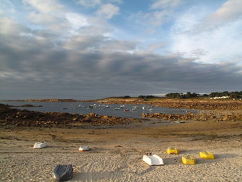 Scenic view of beach against cloudy sky