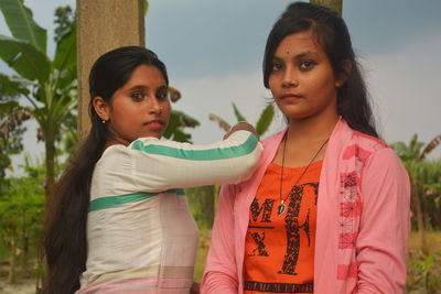 Portrait of smiling teenage girls standing outdoors