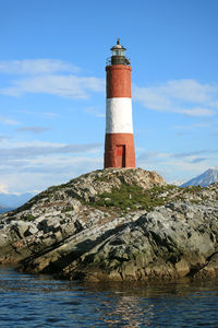 Red and white lighthouse on a rocky islands, beagle channel, ushuaia, tierra del fuego, argentina