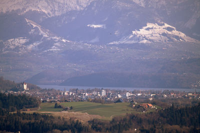 Aerial view of townscape by mountain against sky