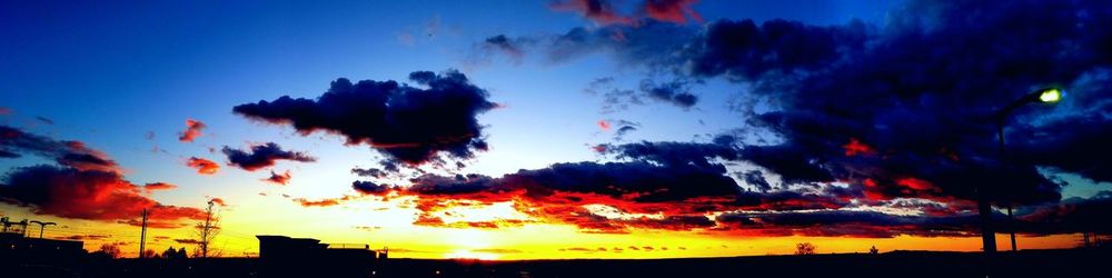 Low angle view of silhouette trees against dramatic sky