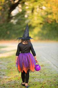 Rear view of woman walking on field