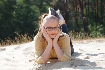 Portrait of young woman sitting on sand