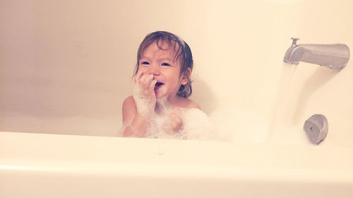 Happy baby girl bathing in bathroom
