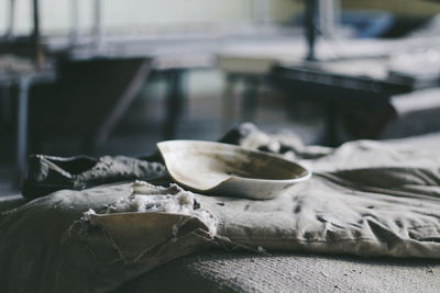 Close-up of broken plate with old pillow on table