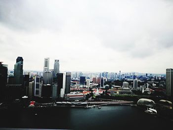 View of cityscape against cloudy sky