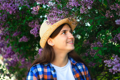 Spring girl. defocus beautiful young woman near blooming spring tree. bush lilac flowers. youth