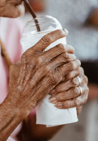 Close-up of woman holding drinking juice from disposable cup