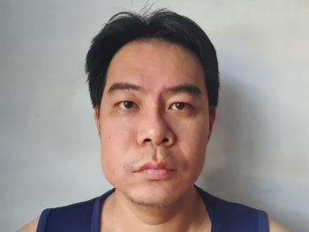 Portrait of young man against wall at home