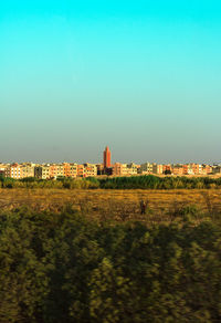 Buildings on field against clear sky