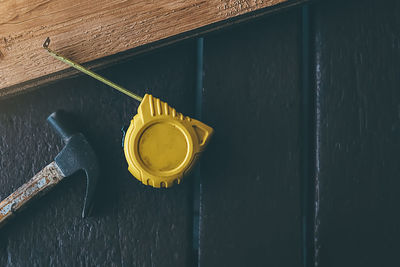 High angle view of yellow container on wooden wall