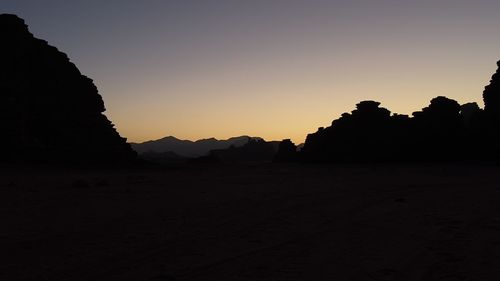 Scenic view of silhouette mountains against clear sky during sunset