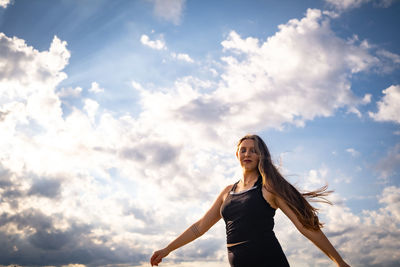 Low angle view of woman standing against sky