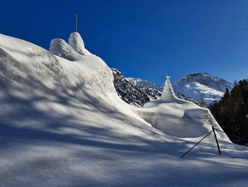 Snow covered mountain against blue sky