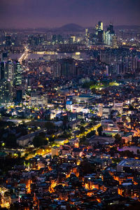 High angle view of illuminated city against sky at dusk