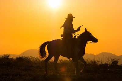 Silhouette man riding horse