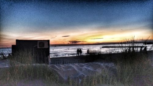 Silhouette man on beach against sky during sunset