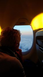 Woman sitting in airplane during sunset