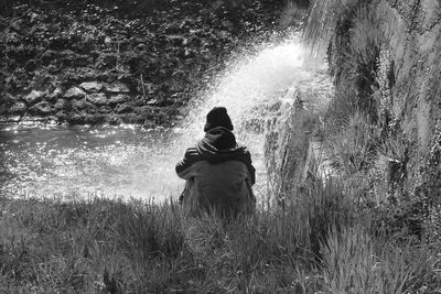 Rear view of man standing on field in forest