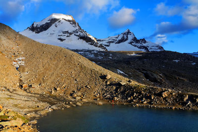 Scenic view of river by mountains against sky at gran paradiso national park