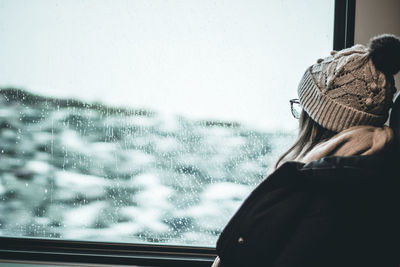 Rear view of woman seen through car window