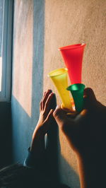 Low section of person holding drink on floor