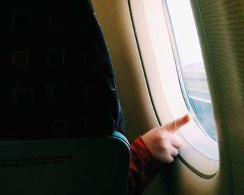 Cropped image of woman looking through window