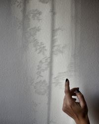 Close-up of woman hand against wall