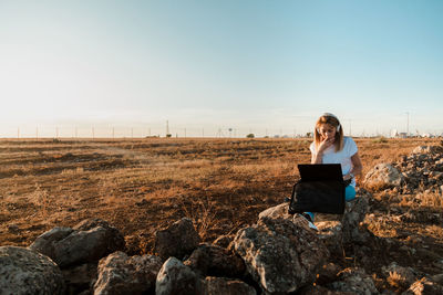 Young woman sitting on rock