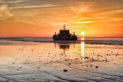 Ship sailing on sea against sky during sunset