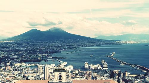 Cityscape by sea against sky